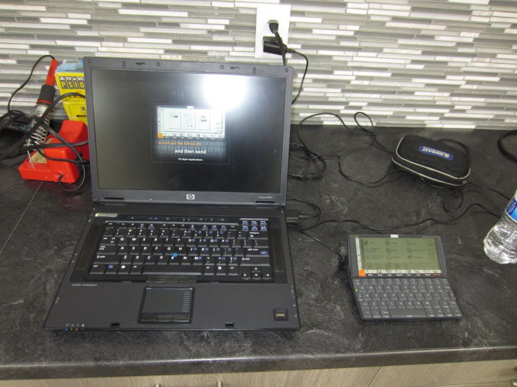 Matt's Psion Series 5 is connected to a laptop via serial cable. This is used to install software and transfer data. The laptop is running the Series 5 demo kiosk program.